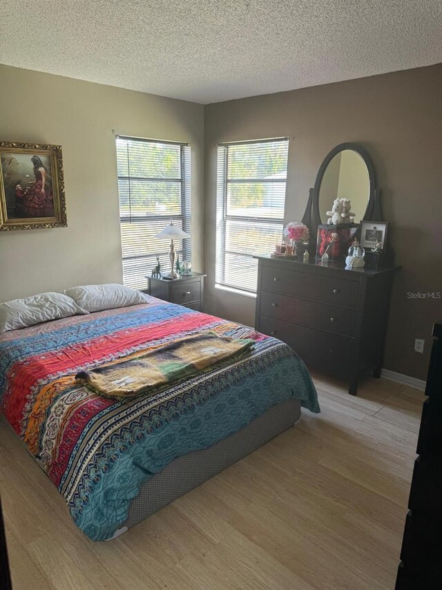 111 Carillo St NE, Palm Bay, FL 32907 - bedroom with a textured ceiling and light wood-style floors