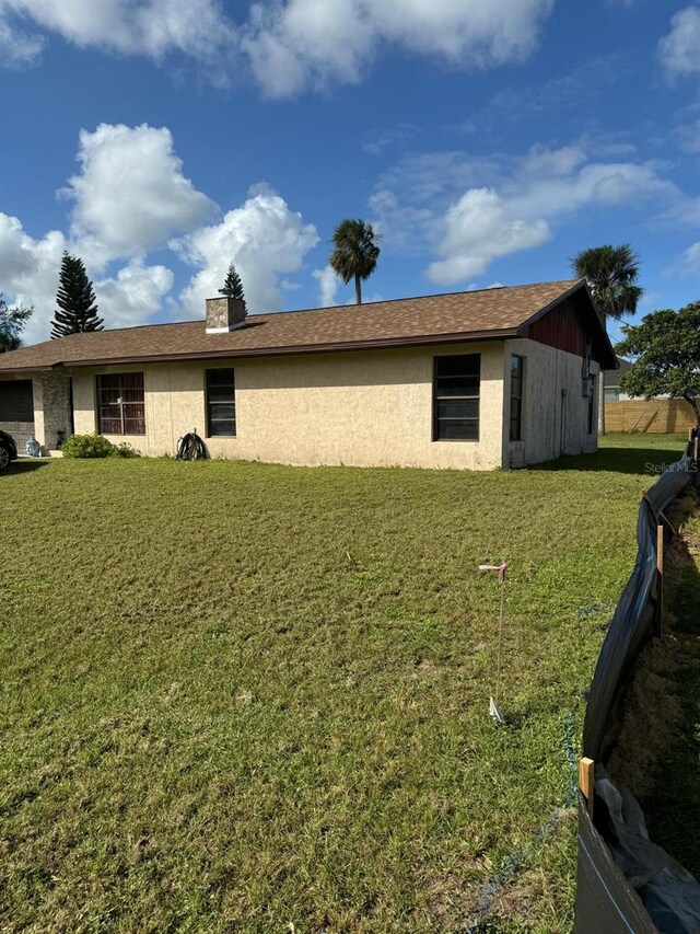 111 Carillo St NE, Palm Bay, FL 32907 - view of home's exterior featuring a chimney and stucco siding