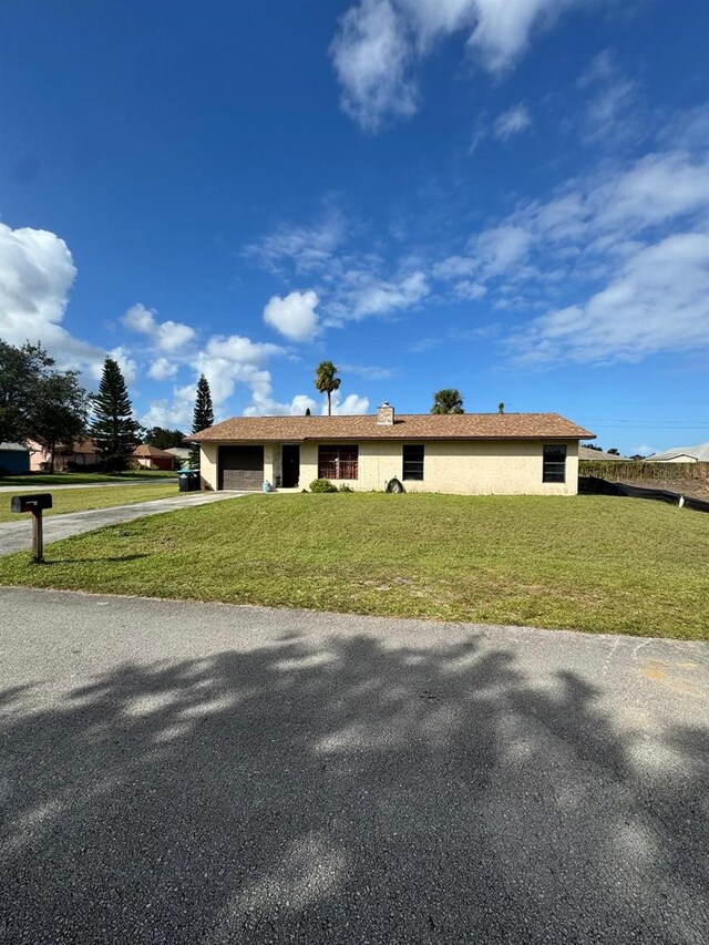 111 Carillo St NE, Palm Bay, FL 32907 - ranch-style house featuring an attached garage, driveway, a front yard, and stucco siding