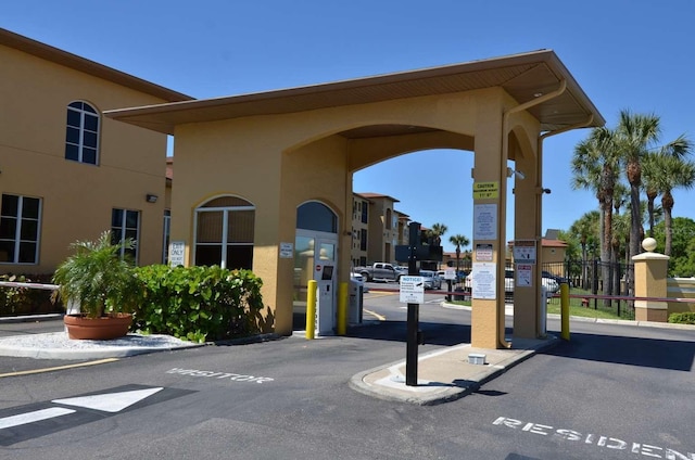 view of street with a gated entry and curbs