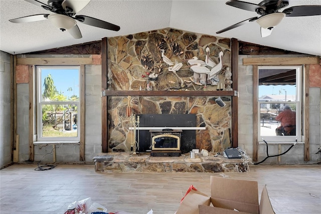 unfurnished living room with lofted ceiling, a textured ceiling, and a wealth of natural light