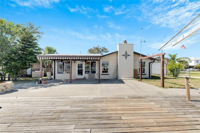 rear view of property featuring a patio and a deck