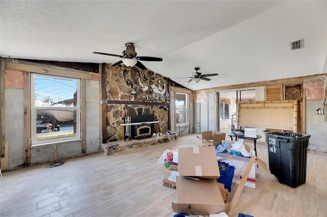 dining space with ceiling fan, a textured ceiling, wood-type flooring, and lofted ceiling