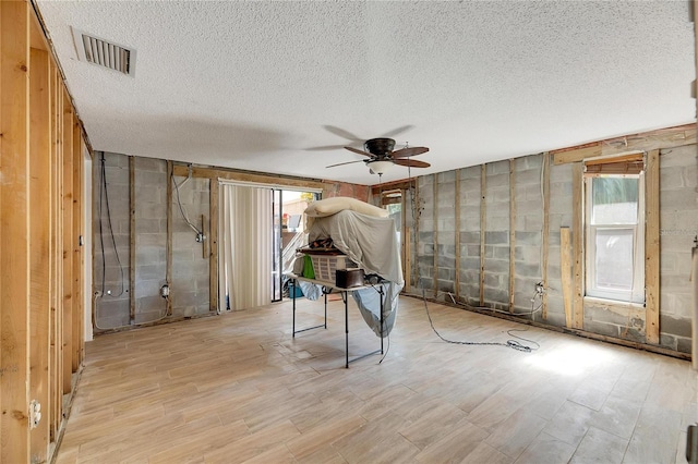 miscellaneous room featuring ceiling fan, a textured ceiling, and light wood-type flooring