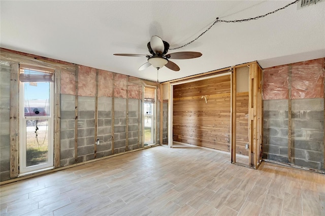 unfurnished room with light hardwood / wood-style flooring, a textured ceiling, and ceiling fan