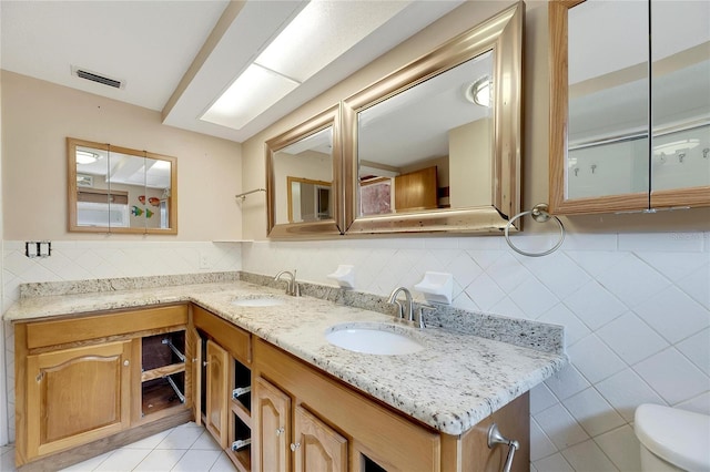 bathroom featuring tile walls, vanity, toilet, and tile patterned floors