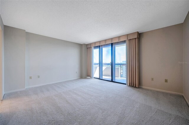 empty room with a water view, a textured ceiling, and carpet