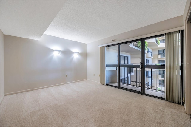 carpeted empty room featuring a textured ceiling