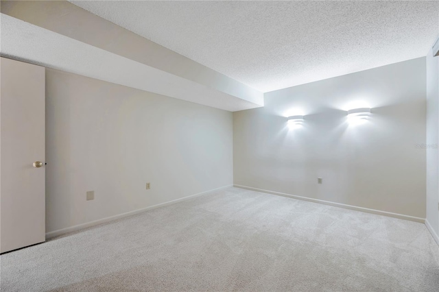 spare room featuring a textured ceiling and light colored carpet