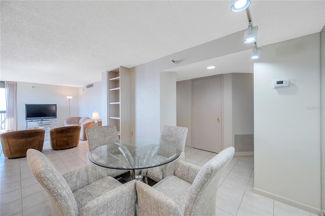 tiled dining area with a textured ceiling