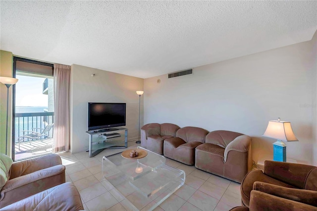 tiled living room featuring a textured ceiling