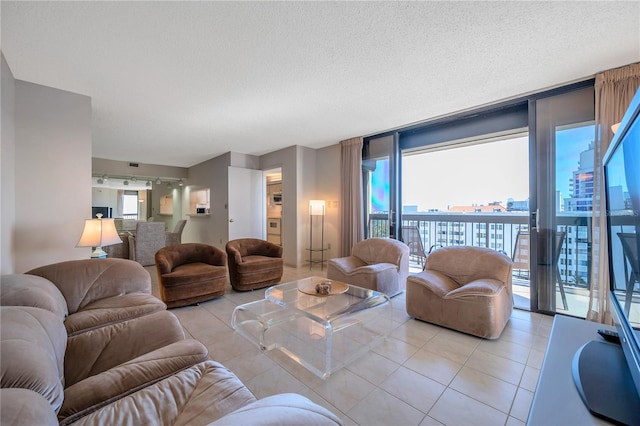 tiled living room featuring a textured ceiling, plenty of natural light, and expansive windows