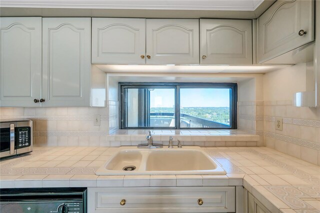 kitchen with dishwashing machine, sink, and white cabinets