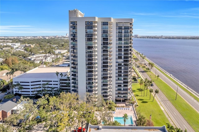 view of building exterior with a community pool and a water view