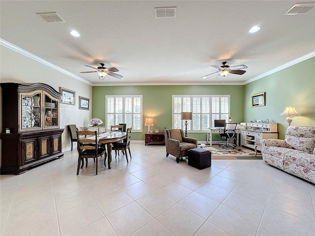 tiled dining area featuring ceiling fan, ornamental molding, and a textured ceiling