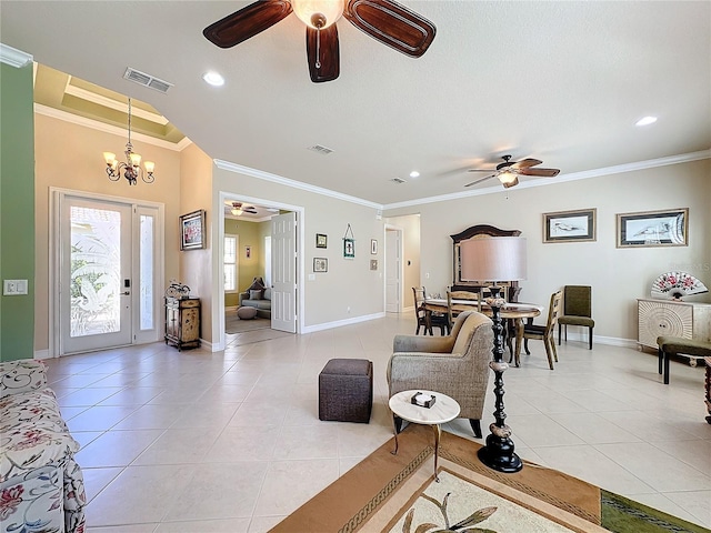 tiled living room with ornamental molding and ceiling fan with notable chandelier