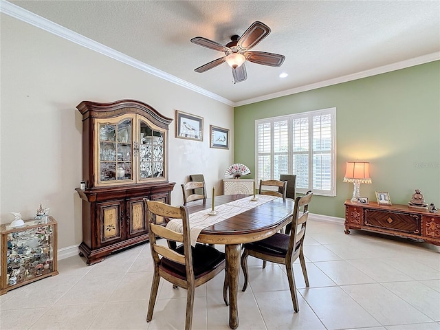 dining room with ornamental molding, a textured ceiling, light tile patterned floors, and ceiling fan