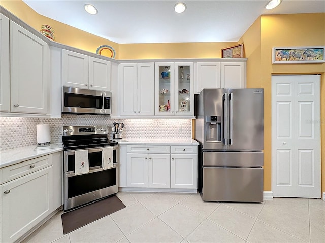 kitchen with white cabinetry, tasteful backsplash, appliances with stainless steel finishes, and light tile patterned floors