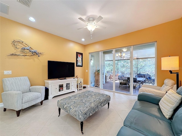 tiled living room featuring ceiling fan with notable chandelier