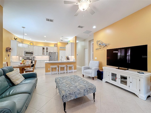 living room with sink, light tile patterned flooring, and ceiling fan