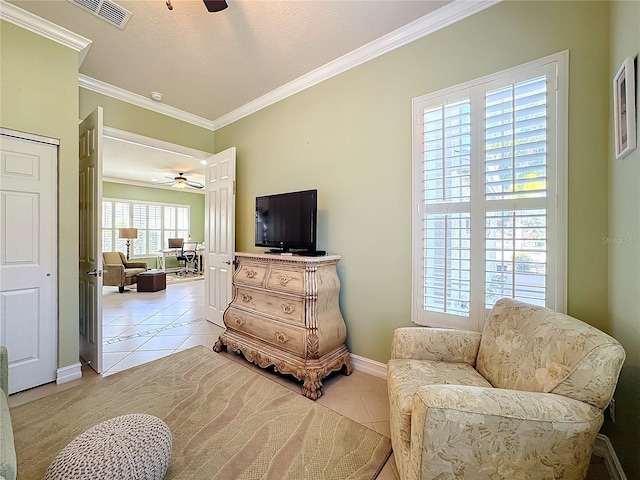 living area featuring ornamental molding, a textured ceiling, light tile patterned floors, and ceiling fan