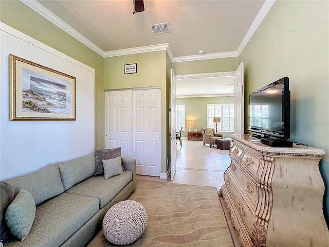 tiled living room featuring crown molding, a textured ceiling, and ceiling fan