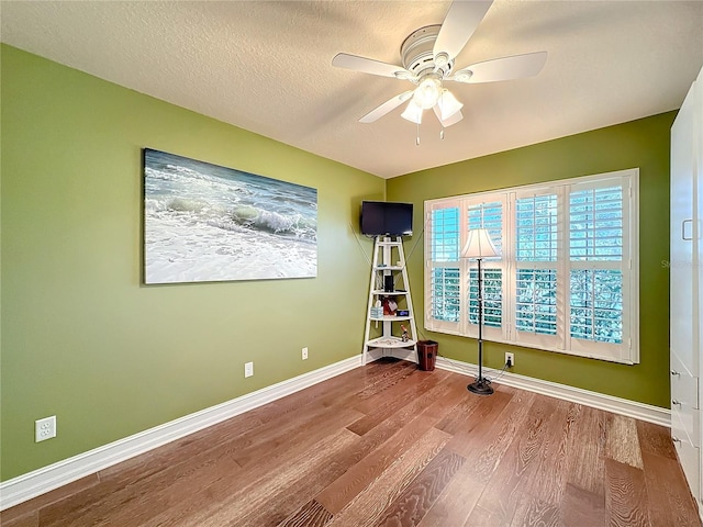 interior space featuring a textured ceiling, wood-type flooring, and ceiling fan