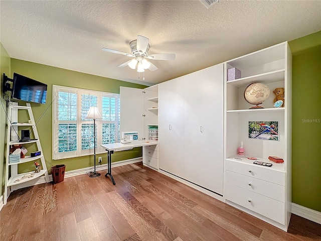 office with light hardwood / wood-style floors, a textured ceiling, and ceiling fan