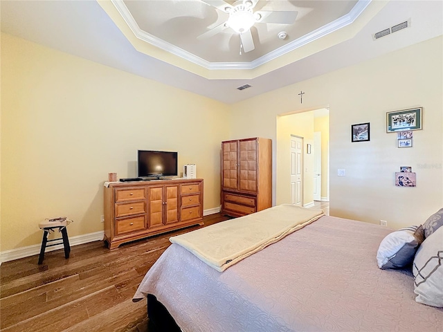 bedroom featuring ornamental molding, hardwood / wood-style floors, a raised ceiling, and ceiling fan