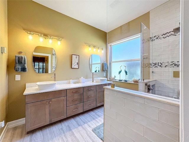 bathroom with vanity, a tile shower, and hardwood / wood-style flooring