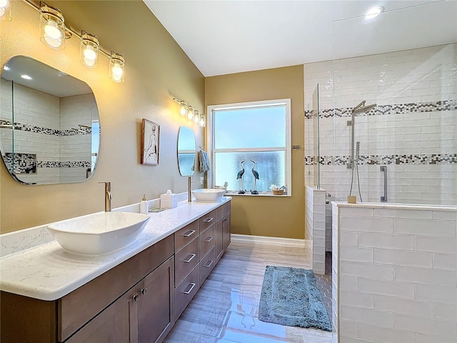 bathroom with vanity, hardwood / wood-style flooring, and tiled shower