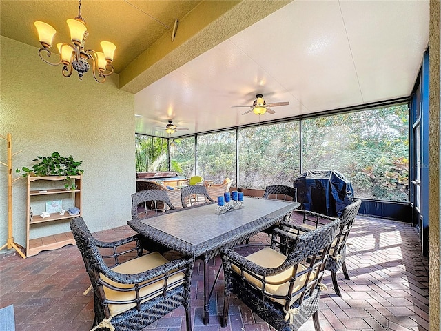 sunroom / solarium featuring ceiling fan with notable chandelier and a healthy amount of sunlight