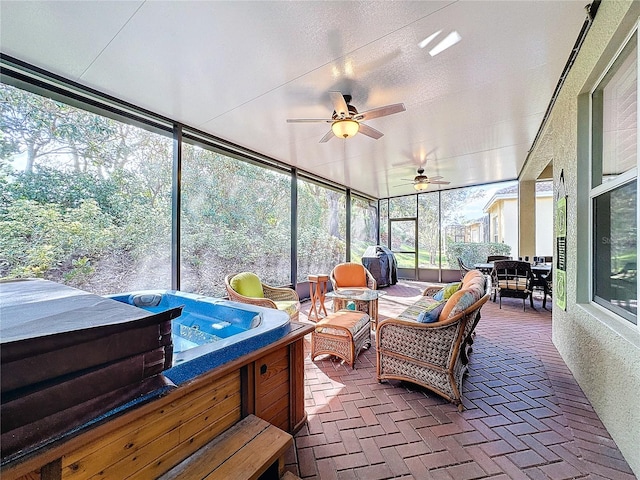 sunroom / solarium with a hot tub and ceiling fan