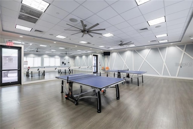 game room with wood-type flooring and a drop ceiling