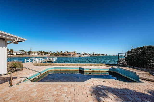 view of pool with a water view and a patio