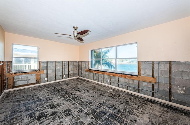 unfurnished room with ceiling fan and plenty of natural light