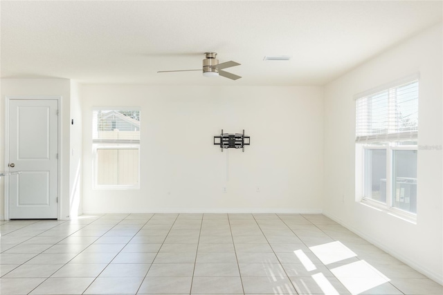 tiled spare room featuring ceiling fan