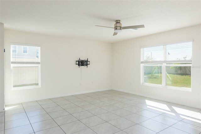 spare room featuring ceiling fan and light tile patterned floors