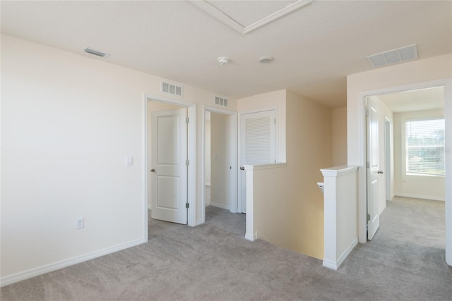 unfurnished room featuring light colored carpet