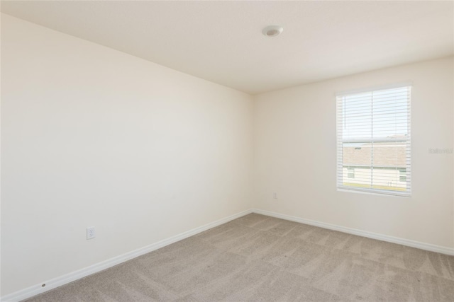 unfurnished room featuring light colored carpet