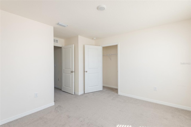 unfurnished bedroom with light carpet and a closet