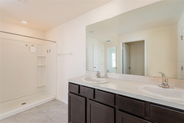 bathroom featuring vanity, a shower, and tile patterned flooring