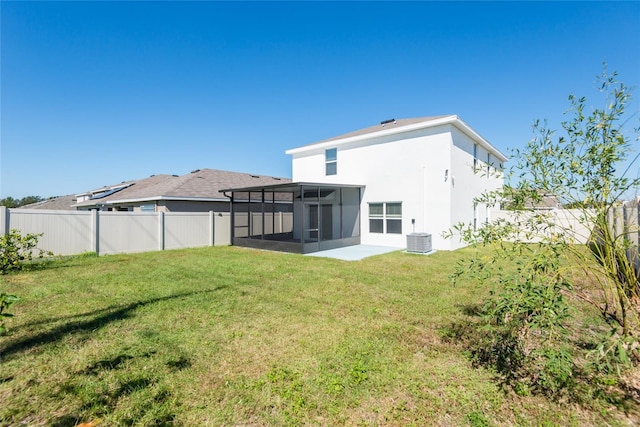 back of property with a lawn, central AC unit, and a sunroom