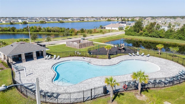 view of pool featuring a patio area, a yard, and a water view