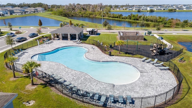 view of pool with a patio, a yard, and a water view