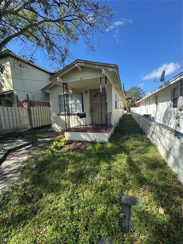 rear view of house featuring a porch and a yard