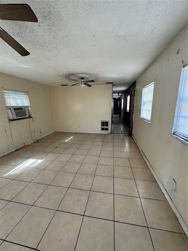 unfurnished living room with ceiling fan, a textured ceiling, light tile patterned floors, and cooling unit