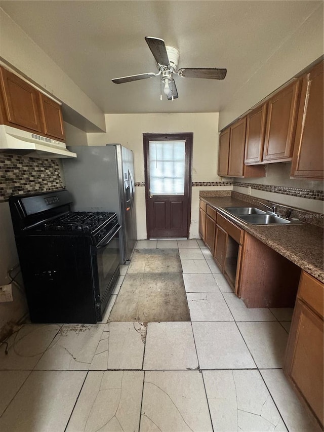 kitchen with light tile patterned floors, backsplash, ceiling fan, black gas stove, and sink