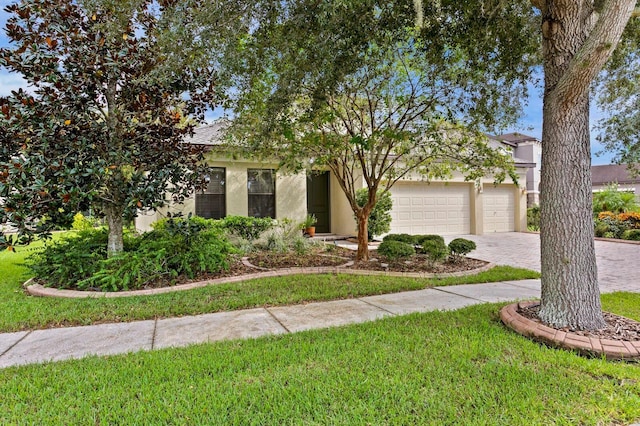 3320 Majestic View Dr, Lutz, FL 33558 - obstructed view of property featuring decorative driveway, a garage, stucco siding, and a front lawn