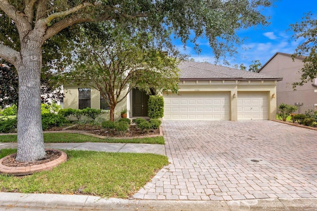 3320 Majestic View Dr, Lutz, FL 33558 - view of front of house featuring decorative driveway, a garage, stucco siding, and a shingled roof